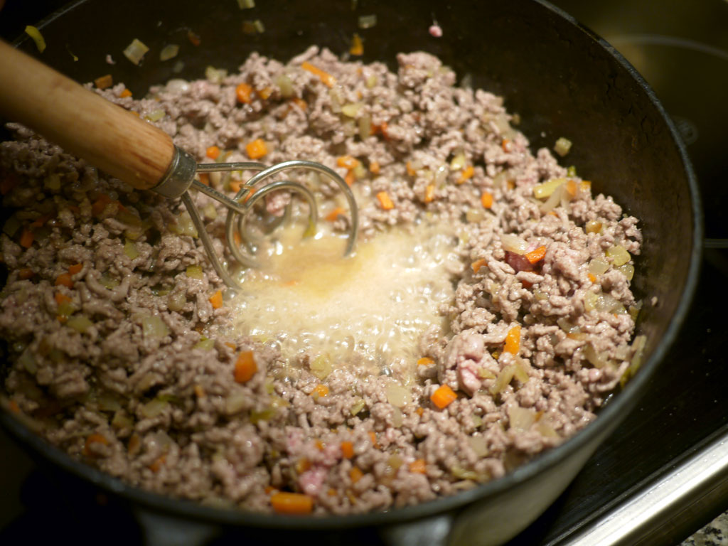 You cannot brown the meat if there is still water in the pot. The water keeps the temperature at 100°C (212°F), and the browning only begins at 130°C (266°F). So the water has to be boiled completely away.