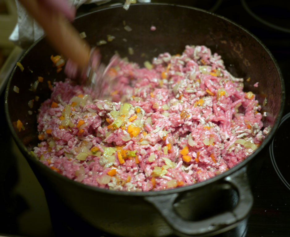 When you fry mincemeat it has a tendency to lump together in the beginning. That is due to a chemical process. Just keep stirring until it is fried grey, at which point it stops lumping.