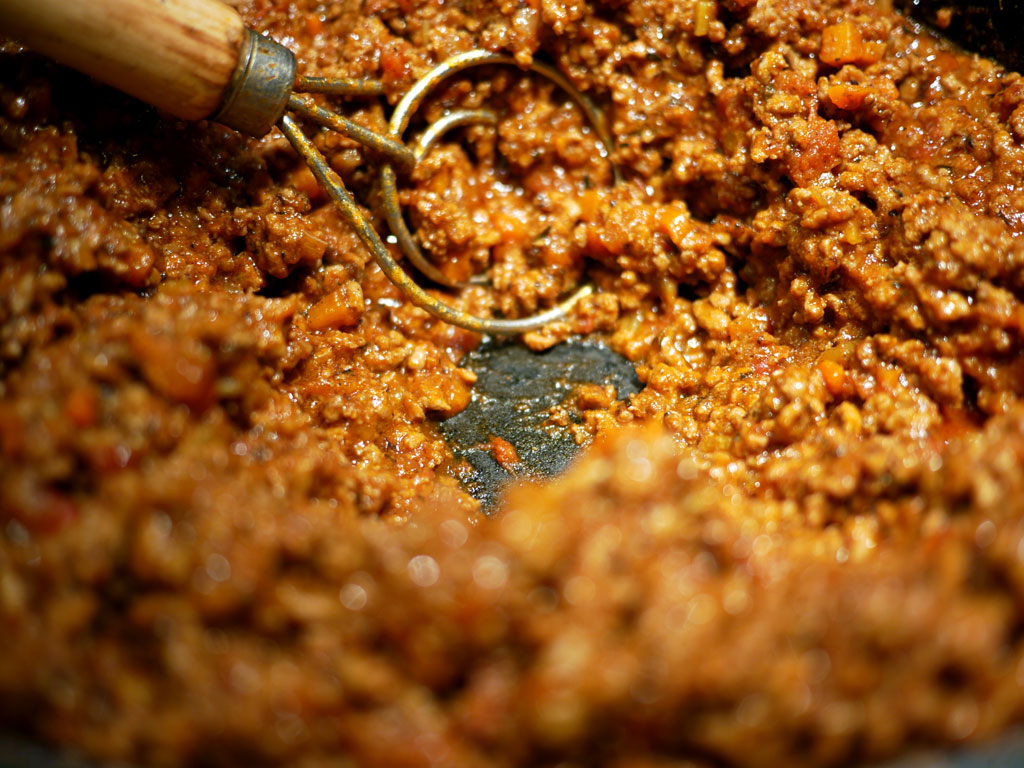 Once you can scrape the bottom of the pan and the sauce does not float right back, the bolognese is done. It should have a deep dark red brown (auburn) color. The color and the taste is deeply concentrated at this stage. Which is why you don't need much of it to flavour your pasta.
